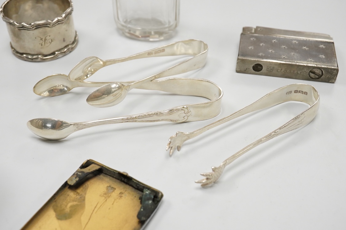 A collection of small silver to include a cigarette case, two napkin rings, three pairs of sugar tongs, a thimble, a lady's wrist watch and a mounted glass toilet jar. together with a 925 fob watch, a 935 mounted lighter